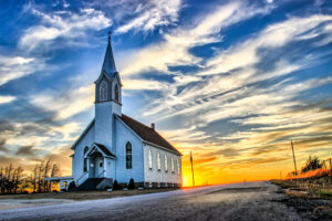 A,lone,wooden,church,at,dusk,with,sunset,clouds,in